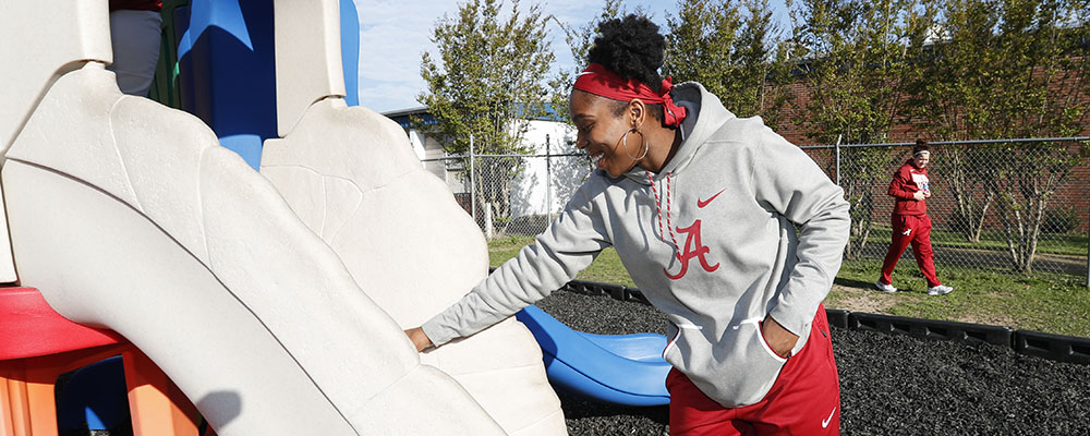 Basketball player doing community service at elementary school playground