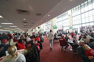 People seated around large round tables enjoying a football game on multiple tvs mounted around the room